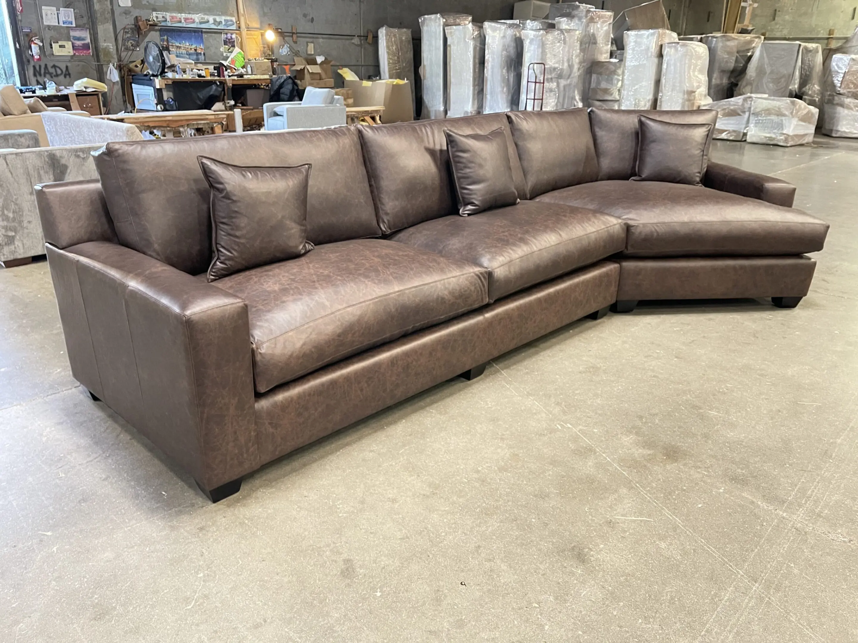 Large brown leather sectional sofa in warehouse