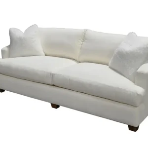 White upholstered sofa with two pillows