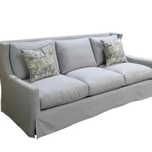 Light gray slipcovered sofa with patterned pillows